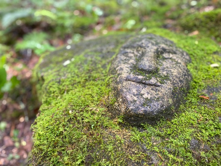 A stone face carved into a rock.